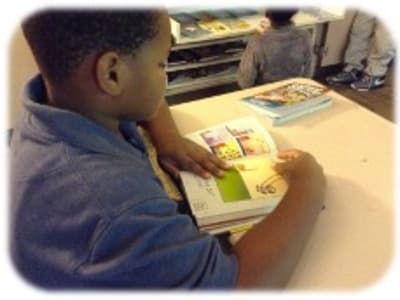 Students reading graphic novels from a classroom library
